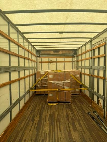 Load bars and straps holding a box truck load